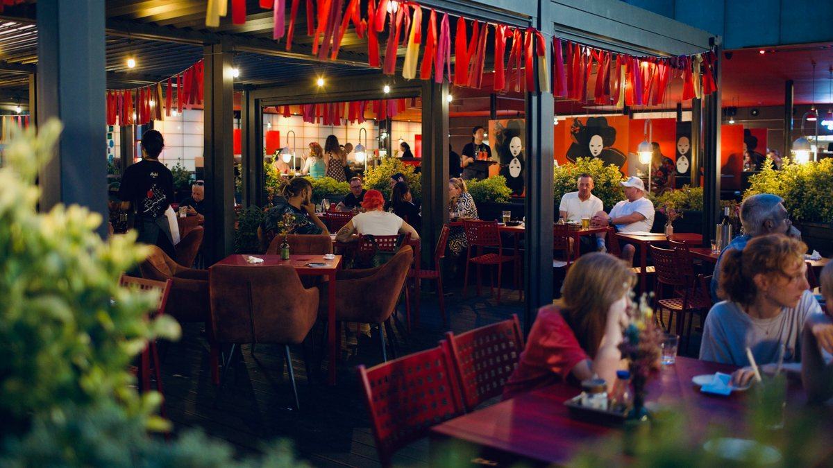 The Moshimo deck on a summer evening, full under the bunting