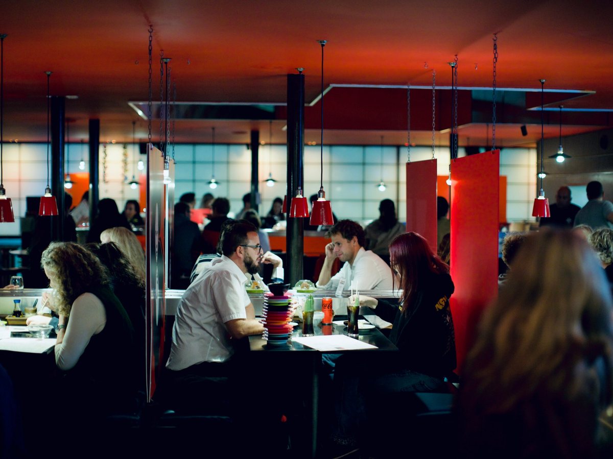 Diners in the booths with a stack of belt plates on the table