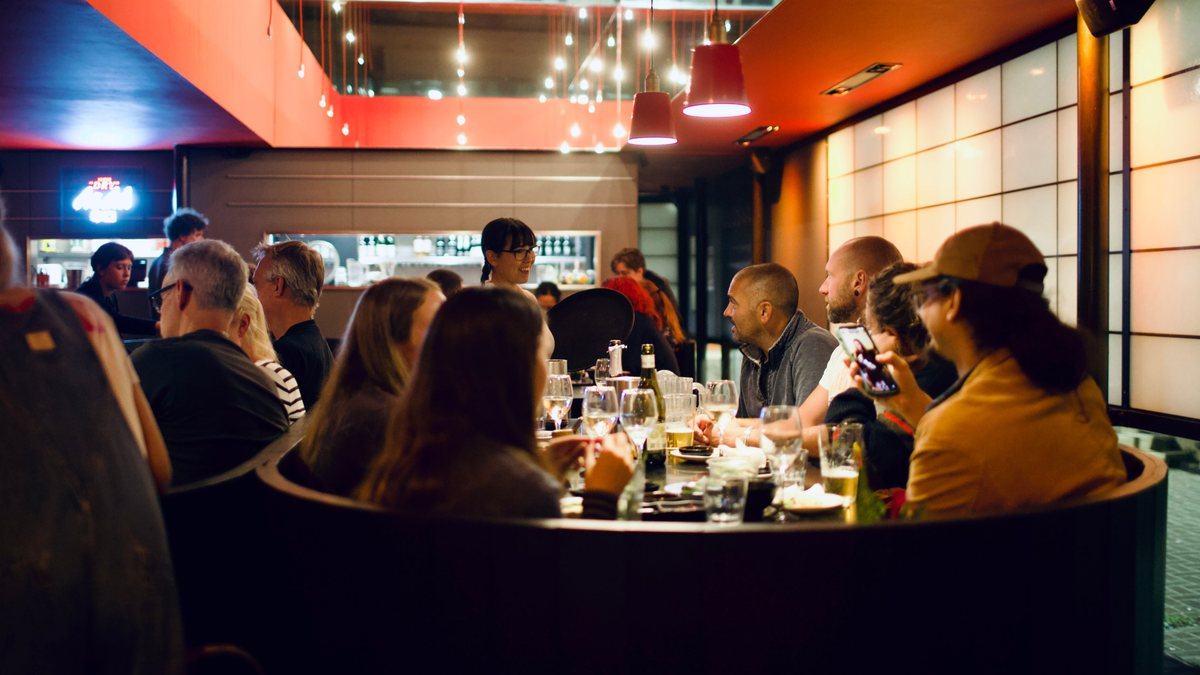 A big group round the curved table inside, drinks on the go